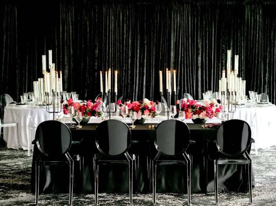 Luxury event rentals Houston black and white table design with tall candles and red floral centerpiece
