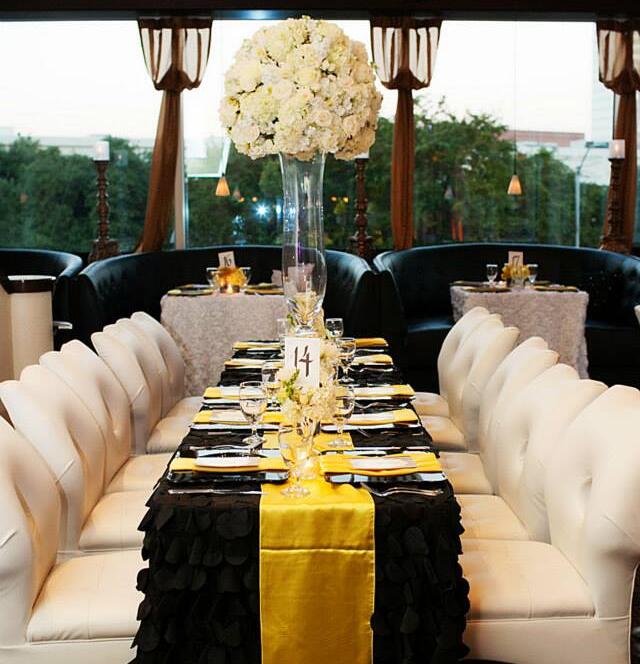 Elegant wedding table setup with black and gold linens and floral centerpiece