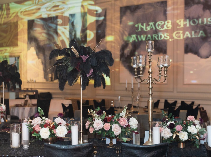 Elegant ballroom setup by EB Inc for a corporate events company gala dinner with chandeliers, floral décor, and black seating.