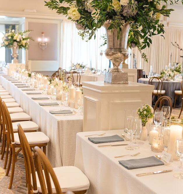 Houston wedding color palette with ivory linens, white florals, and greenery at a ballroom reception