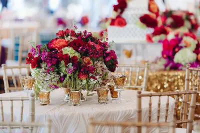 Quinceanera decorations Houston tablescape with gold sequin linen and bold florals